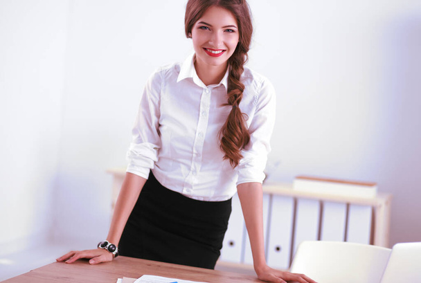 Attractive businesswoman with her arms crossed standing in office - Foto, Bild