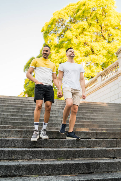 Gay couple holding their hands and walking. - Foto, afbeelding