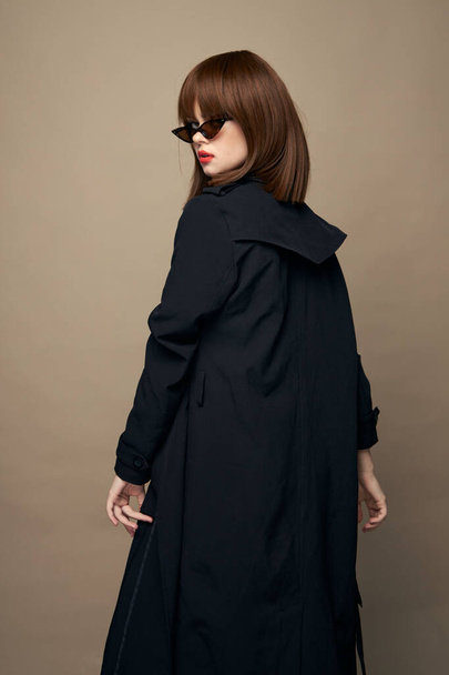 Kaunis nainen takki vyö tyylikäs tyyli hauskaa beige tausta  - Valokuva, kuva