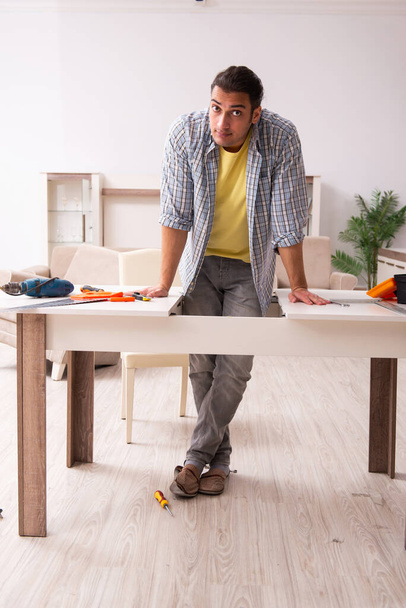 Joven carpintero masculino reparando muebles en casa - Foto, Imagen