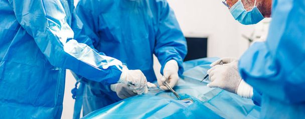 Professional anesthesiologist doctor medical team and assistant preparing patient to gynecological surgery performing operating with surgery equipment in modern hospital operation emergency room - Photo, Image