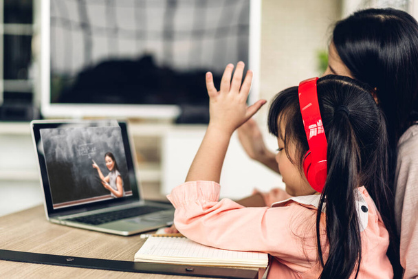 Мати і азіатська дівчинка вчиться і дивиться на портативний комп'ютер, роблячи домашнє завдання, вивчаючи знання з онлайн-навчанням e-learning system.childs video conference with teacher home
 - Фото, зображення
