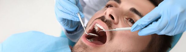 Dentist examining patient's teeth in clinic - Foto, Imagem