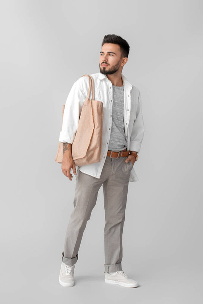 Fashionable young man on grey background - Photo, Image