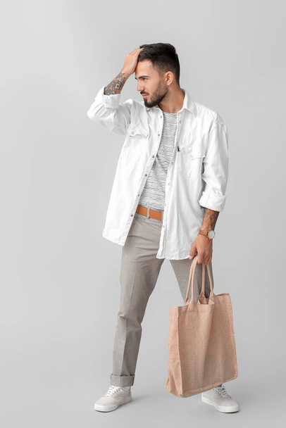 Fashionable young man on grey background - Φωτογραφία, εικόνα