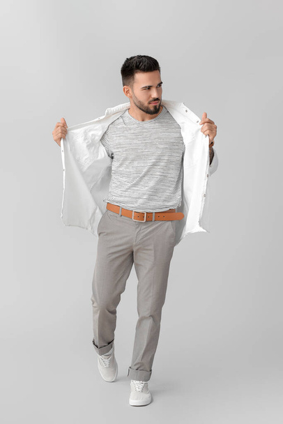 Fashionable young man on grey background - Zdjęcie, obraz