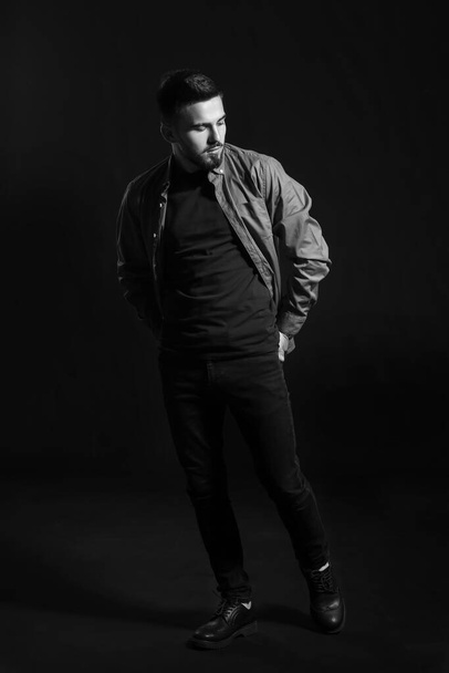 Black and white portrait of fashionable young man on dark background - Zdjęcie, obraz