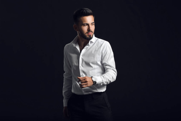 Fashionable young man on dark background - Photo, Image