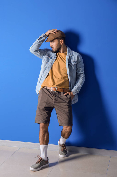 Fashionable young man on color background - Photo, image