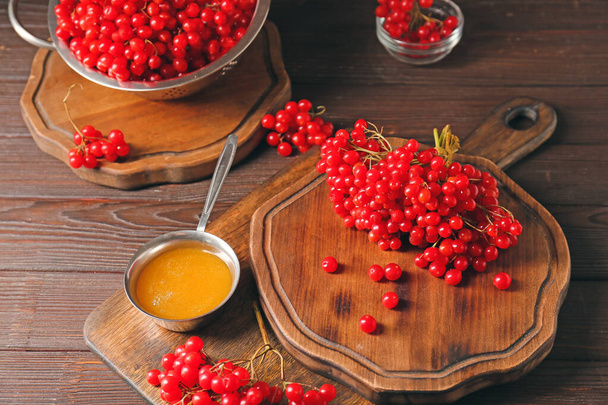 Свежие ягоды вибурнума с медом на столе - Фото, изображение