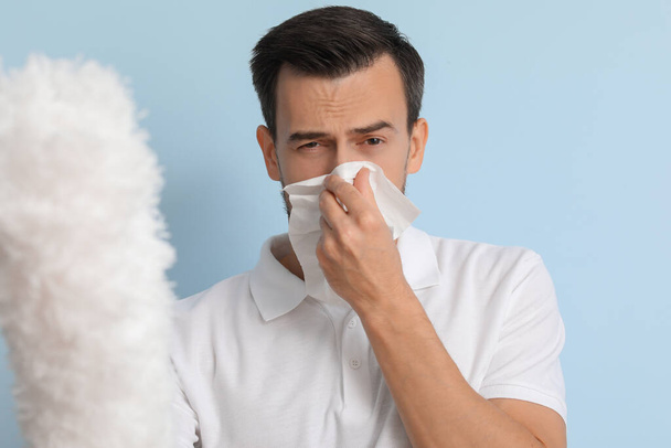 Homme allergique avec brosse à poussière sur fond de couleur - Photo, image