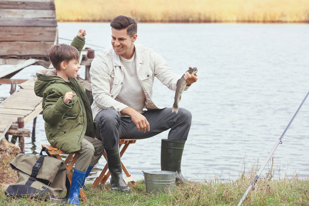 少年と父親は川で釣りをしていた - 写真・画像