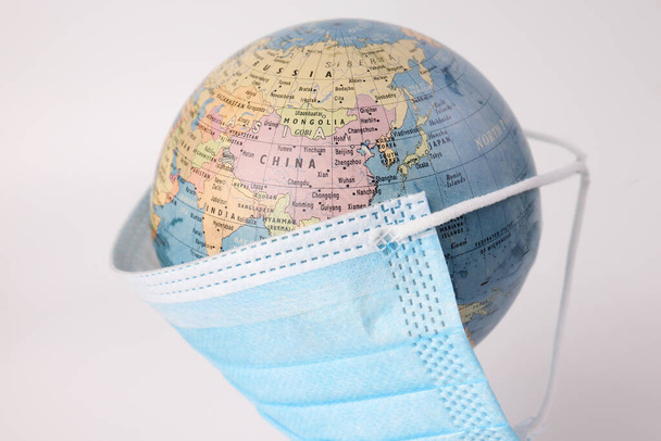 Globus Planet Weltkarte Erde mit Gesichtsmaske auf weißem Hintergrund - Foto, Bild