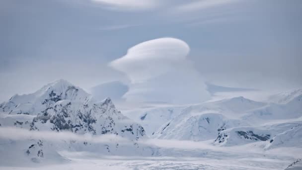 Clouds float above snow mountain ranges timelapse. Amazing Antarctic winter nature landscape - Footage, Video
