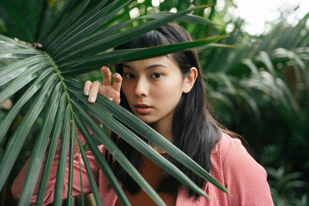 Крупный план портрета - азиатская деловая женщина в формальной рубашке, позирующая с листом. - Фото, изображение
