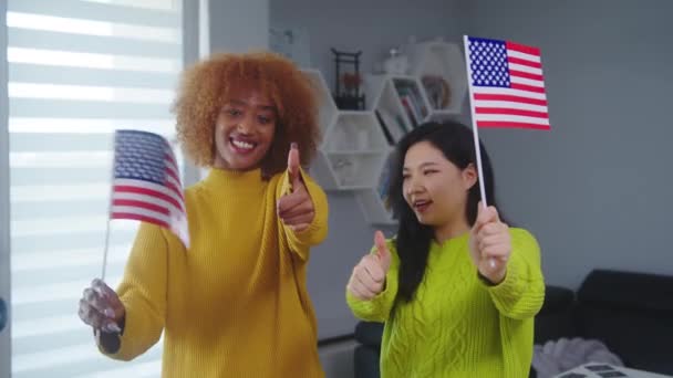 Многорасовая дружба и равенство. Африканская американка и азиатка с флагами США. Програма обмена студентами - Кадры, видео