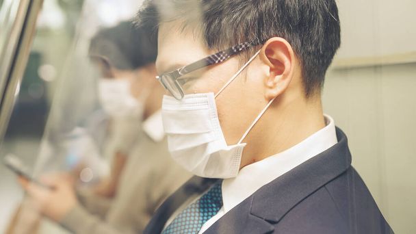 Young man wearing face mask travels on crowded subway train - Φωτογραφία, εικόνα
