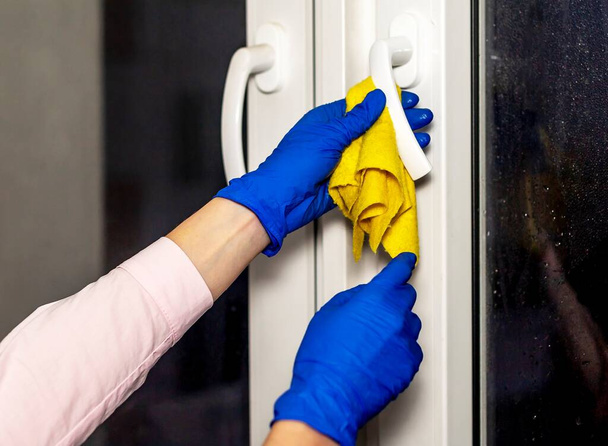 Window handles cleaning or sanitizing with sanitizer at night. - Photo, Image