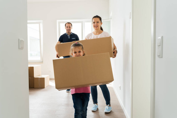 Family Couple With Cardboard Boxes Moving Into New Home - Фото, изображение