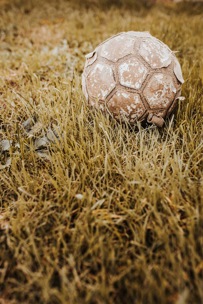 Vieux ballon de football en cuir vintage et baskets déchirées - jeu d'enfant  - Photo, image
