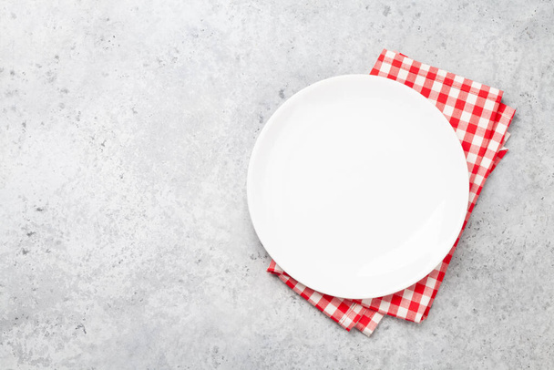 石のテーブルの上に白い空のプレートとナプキン。トップビューフラットはあなたの食事のためのスペースとレイアウト - 写真・画像