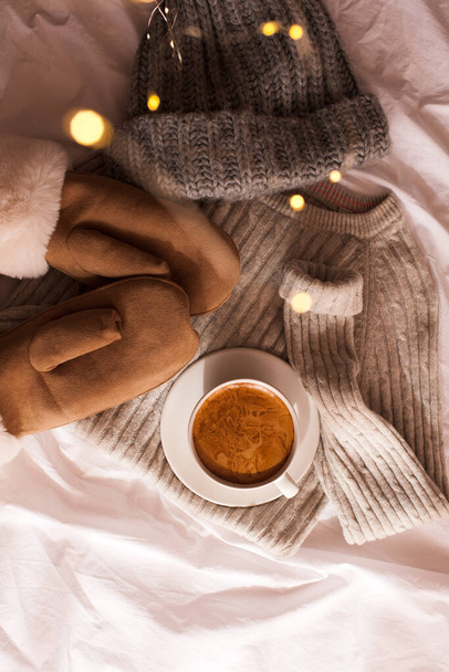 Roupas de inverno: chapéu de malha, luvas, blusa de lã e xícara de café na cama closeup. Vista superior. Bom dia. Temporada de férias de inverno. - Foto, Imagem