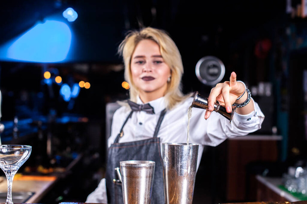 Carismatico ragazza barman pone i tocchi finali su un drink al nightclub - Foto, immagini