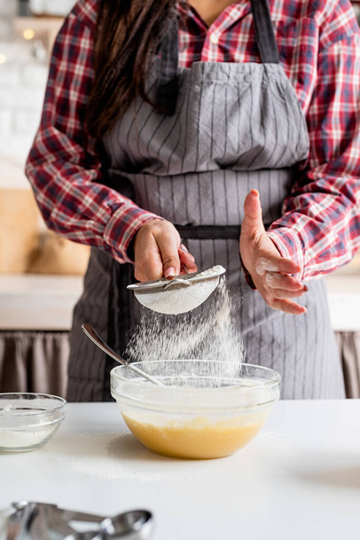 Ruoanlaitto ja leivonta. Nuori latino nainen kaatamalla jauhoja taikina ruoanlaitto keittiössä - Valokuva, kuva