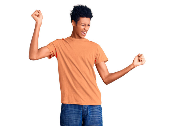 Young african american man wearing casual clothes dancing happy and cheerful, smiling moving casual and confident listening to music  - Photo, Image