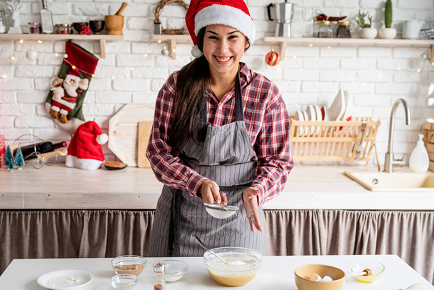 料理とベーキング.若いラテン語の女性は、台所で生地の調理に小麦粉を注ぐ - 写真・画像
