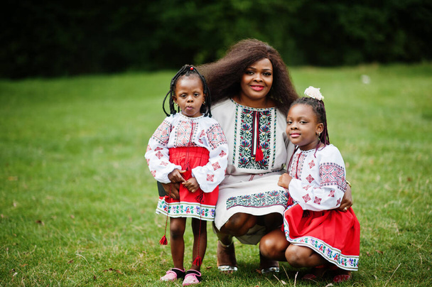 African mother with daugters in traditional clothes at park.  - Photo, Image