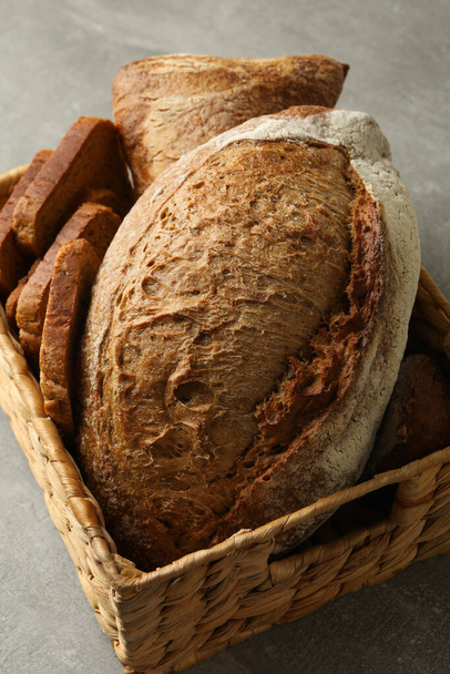 Basket with fresh bread on gray table - Photo, Image