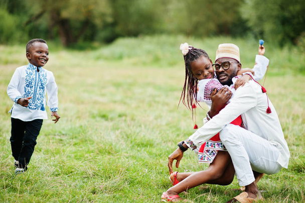 Africký otec s dětmi v tradičním oblečení v parku.  - Fotografie, Obrázek