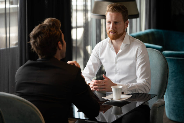 Handsome two young businessmen have a meeting in cafe - Фото, изображение