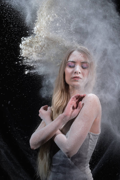 Portrait of a girl in a black bodysuit with flour - Foto, afbeelding