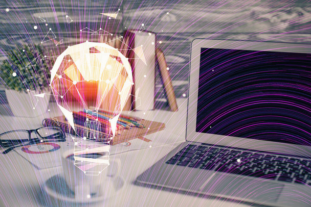 Computer on desktop in office with bulb icon hologram. Double exposure. Concept of idea. - Fotó, kép