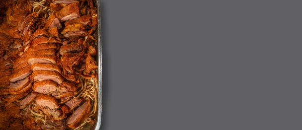 Banner s asijským rychlým občerstvením, smažená kachna s čínskými nudlemi ve velkém kovovém podnosu umístěném na tmavě šedém pevném pozadí s kopírovacím prostorem pro text - Fotografie, Obrázek