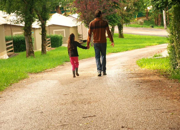 Bir baba ve kızın arkadan yürüyüşünün fotoğrafı. - Fotoğraf, Görsel