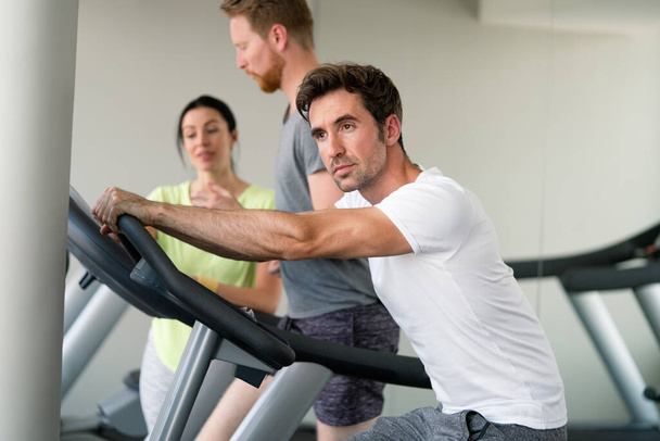 Group of fit people at the gym exercising on the cardio machines - Photo, Image