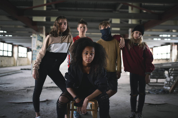 Group of teenagers gang standing indoors in abandoned building, bullying concept. - Foto, immagini