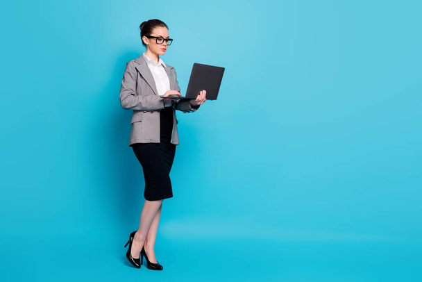 Full length body size view of nice focused lady geek IT expert hands laptop working remotely isolated over bright blue color background - Foto, imagen