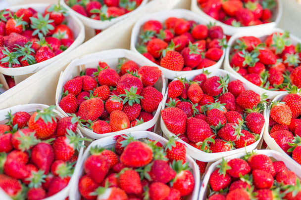 Verse aardbeien in dozen op de wekelijkse markt, close-up kan worden gebruikt als achtergrond. Verse rijpe aardbeien - Foto, afbeelding