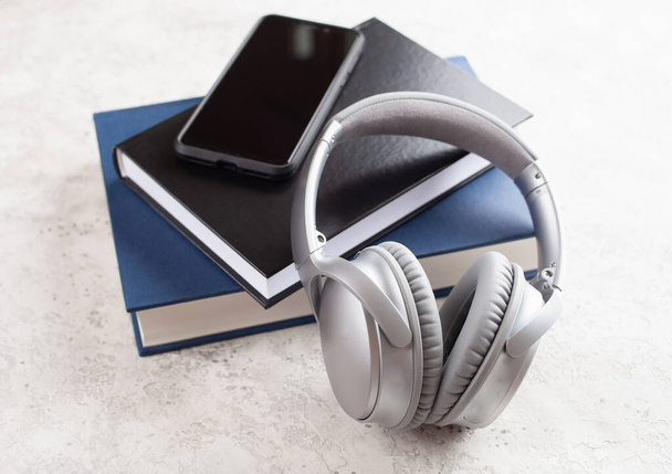 audiobook koncepció modern vezeték nélküli fejhallgató okostelefon és könyv - Fotó, kép