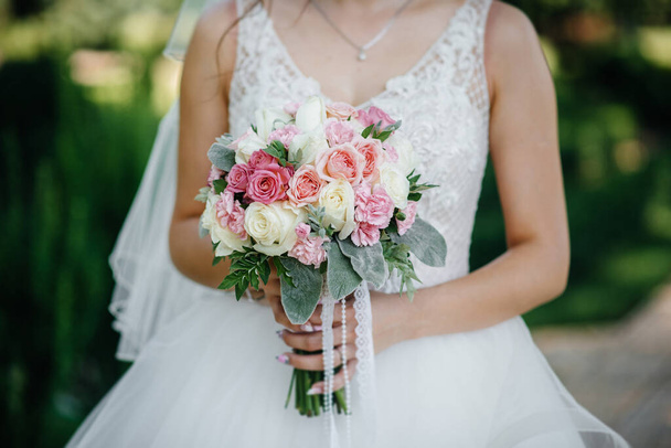 Beautiful and sophisticated wedding bouquet close-up holds the bride in her hands. Wedding bouquet - Valokuva, kuva