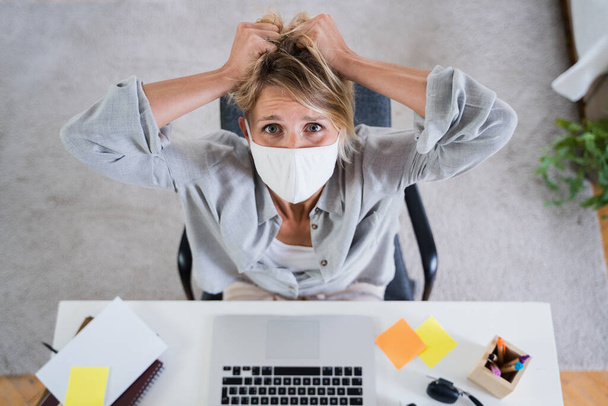 Vue d'ensemble de la femme à l'intérieur du bureau se sentant stressée, concept de santé mentale et de coronavirus. - Photo, image
