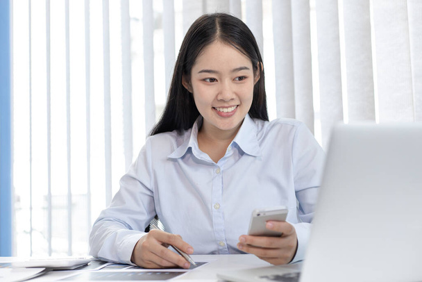 Asiatico donna sta studiando online via internet con un sorriso allegro, stare a casa, Nuovo normale, Covid-19 coronavirus, Distanziamento sociale, Internet learning. - Foto, immagini