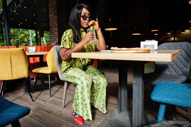 Glamour african american woman eating pizza and drink lemonade at restaurant. - Φωτογραφία, εικόνα