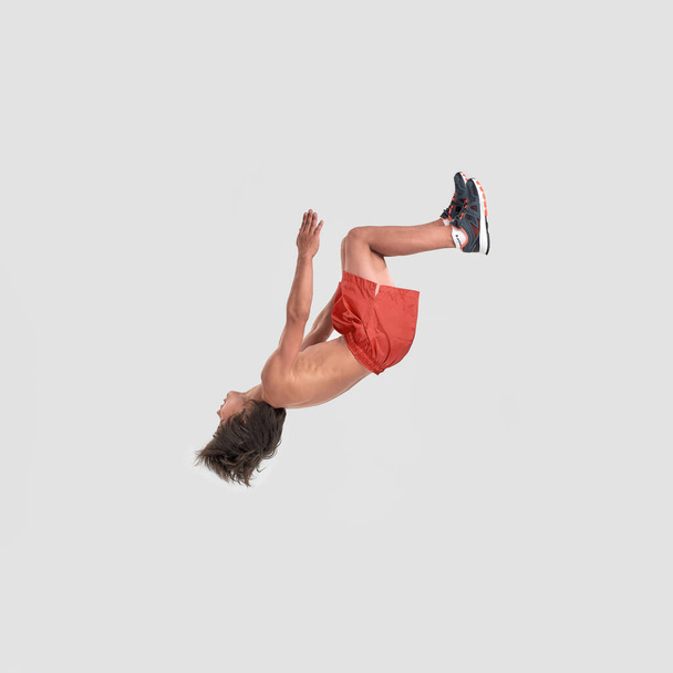 Full length shot of little sportive boy child in shorts jumping isolated over white background - Фото, зображення