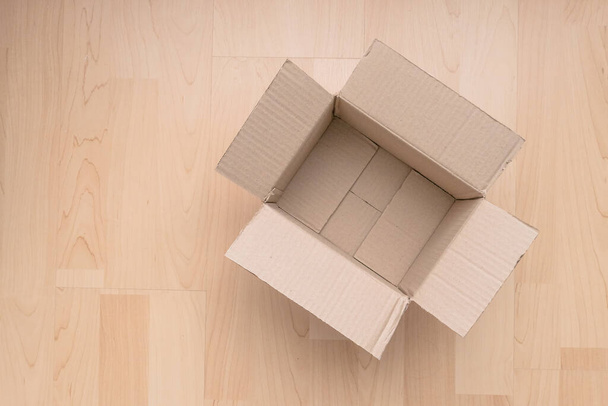 Empty open rectangular cardboard box on wood background. Shopping online object background. Shipping parcel object. - 写真・画像
