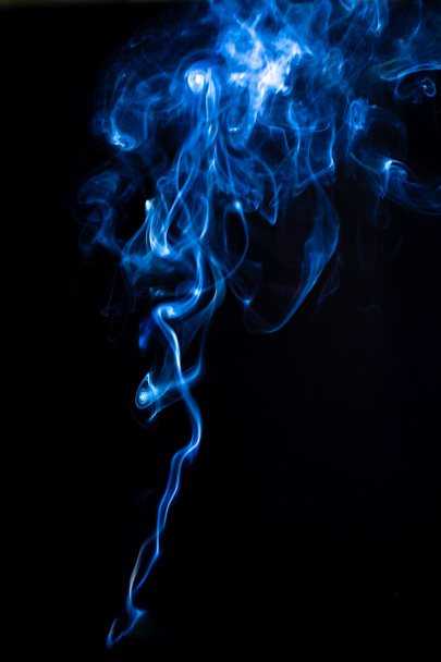 Fekete háttérrel izolált füstcseppek. Kavargó füst kék háttérvilágítással, függőleges fotózás design - Fotó, kép